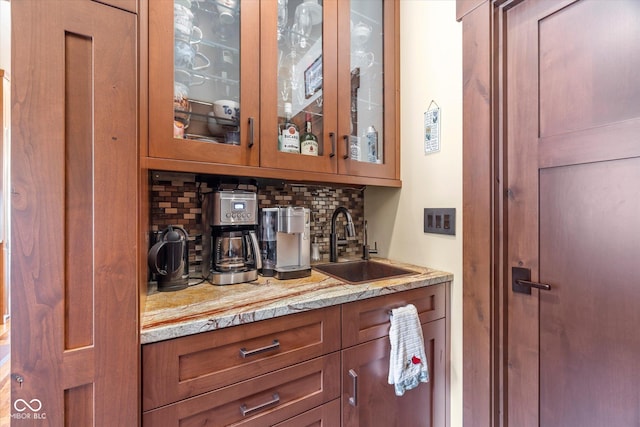 bar featuring backsplash and a sink