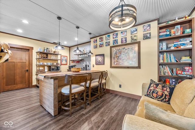 indoor wet bar with baseboards, wood finished floors, recessed lighting, and hanging light fixtures