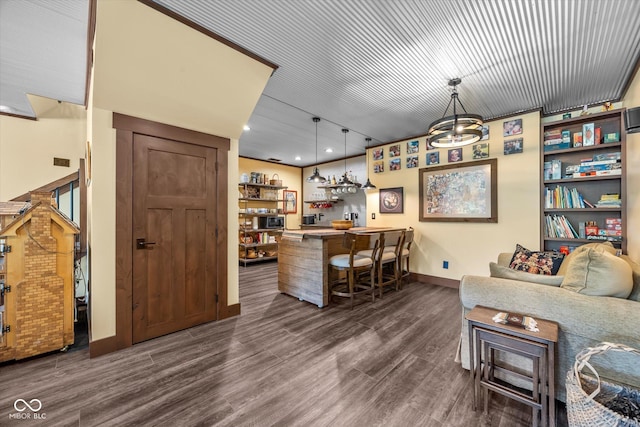 indoor dry bar with baseboards, dark wood-style floors, pendant lighting, and recessed lighting