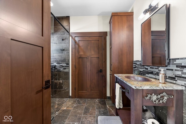 full bathroom featuring tiled shower, backsplash, and vanity