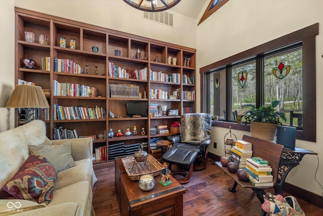 living area featuring wood finished floors, baseboards, and lofted ceiling