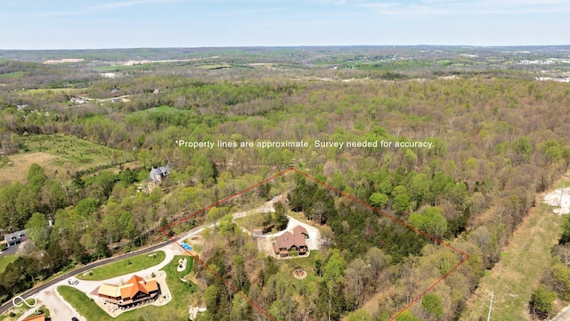 aerial view of property and surrounding area featuring a forest and property boundaries highlighted