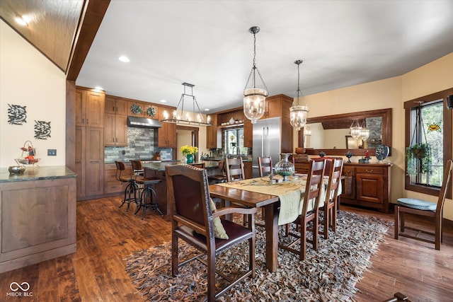 dining space featuring healthy amount of natural light, dark wood-style flooring, recessed lighting, and a chandelier