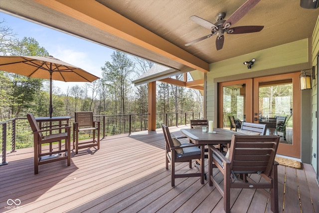 deck with outdoor dining space and ceiling fan
