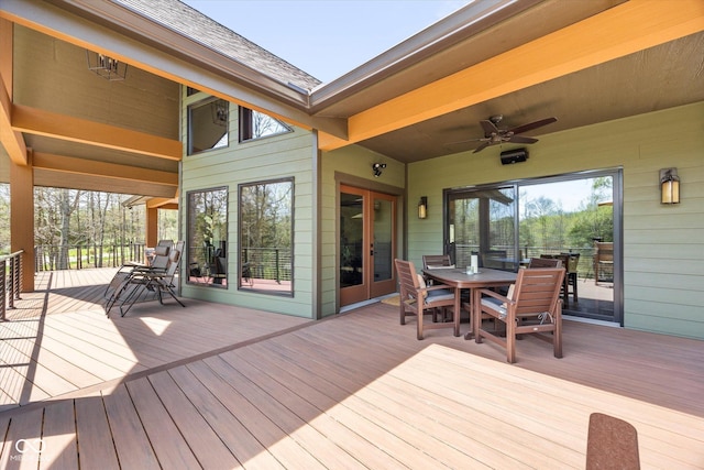 wooden deck with outdoor dining space and ceiling fan