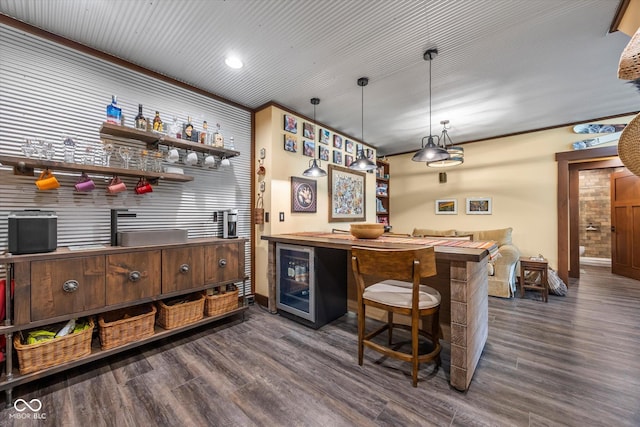 indoor dry bar with beverage cooler, dark wood-style floors, recessed lighting, baseboards, and hanging light fixtures