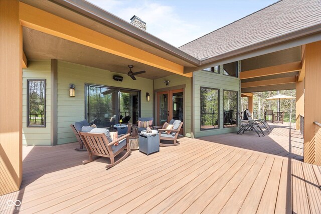 wooden terrace with an outdoor living space with a fire pit and ceiling fan