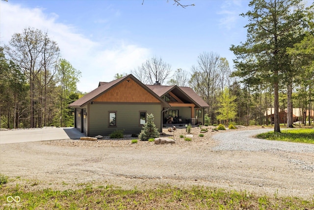 view of side of property with gravel driveway and a garage