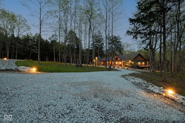 view of dirt / gravel road with a forest view