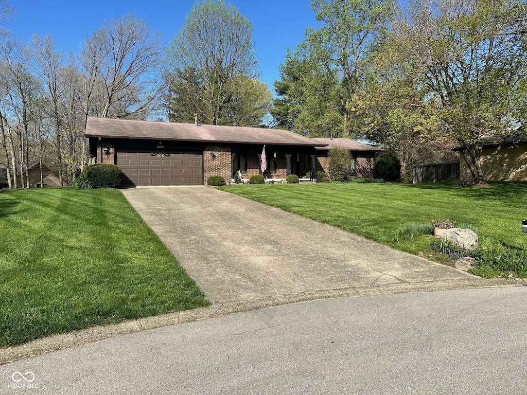 3920 Pigeon Creek Ln, Indianapolis, IN 46234 - ranch-style house with an attached garage, brick siding, a front yard, and concrete driveway