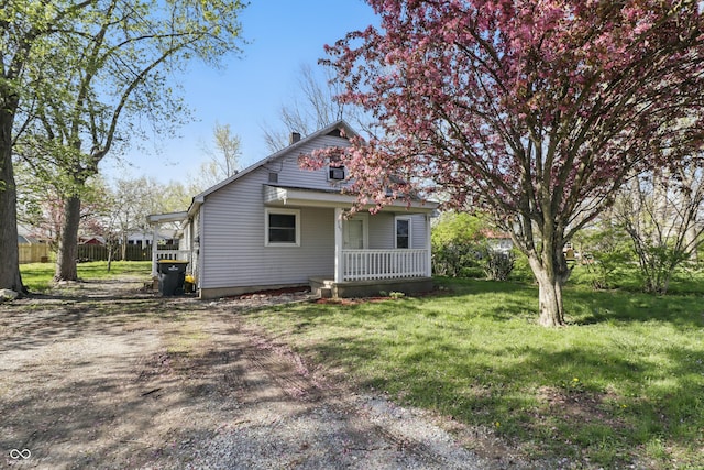 exterior space with a chimney, covered porch, and a front yard