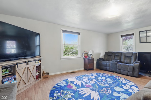 living room featuring baseboards, wood finished floors, and visible vents