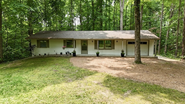 7550 N Lakewood Dr, Unionville, IN 47468 - single story home with an attached garage, dirt driveway, a front lawn, a porch, and a view of trees