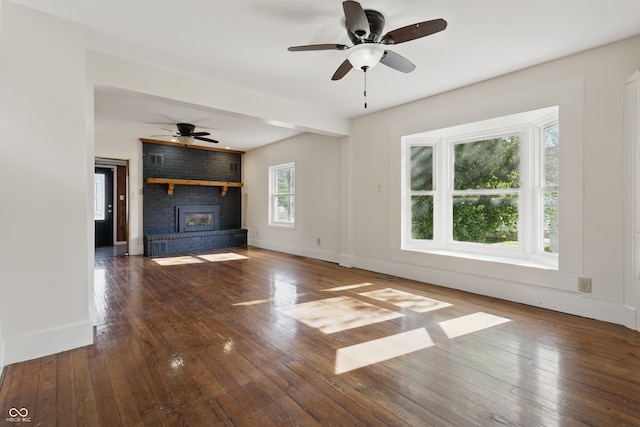 911 W Washington Ave, Shelbyville, IN 46176 - unfurnished living room featuring a brick fireplace, hardwood / wood-style floors, ceiling fan, and baseboards