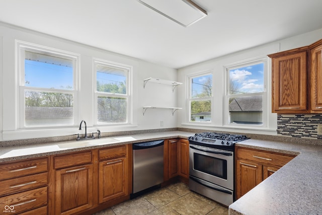 911 W Washington Ave, Shelbyville, IN 46176 - kitchen with brown cabinetry, a sink, a wealth of natural light, and stainless steel appliances
