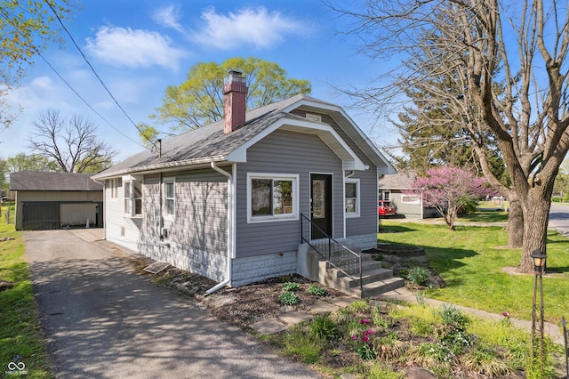 911 W Washington Ave, Shelbyville, IN 46176 - bungalow-style home featuring a chimney, entry steps, an outbuilding, and a front yard