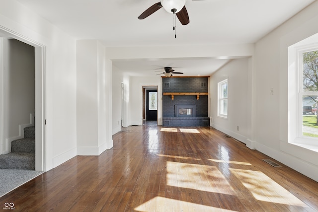 911 W Washington Ave, Shelbyville, IN 46176 - unfurnished living room featuring stairway, a healthy amount of sunlight, wood-type flooring, and ceiling fan