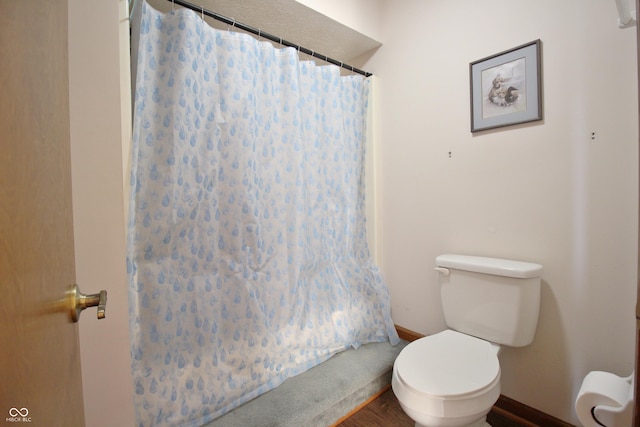 bathroom with wood finished floors, toilet, baseboards, and a shower with curtain