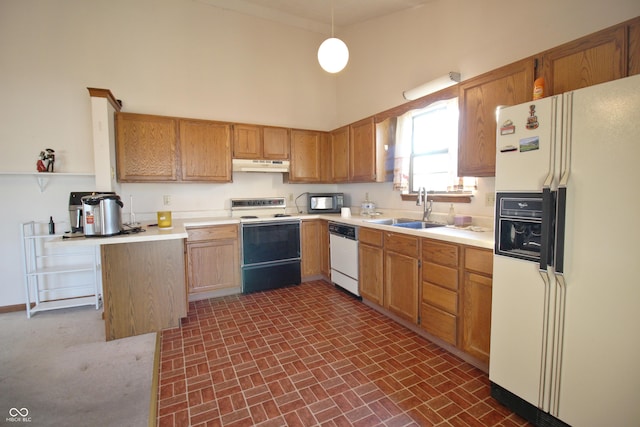 kitchen featuring under cabinet range hood, a sink, white appliances, and light countertops