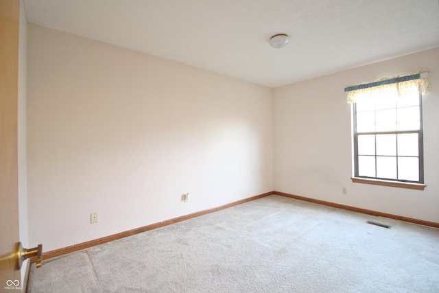 unfurnished room featuring light carpet, baseboards, and visible vents