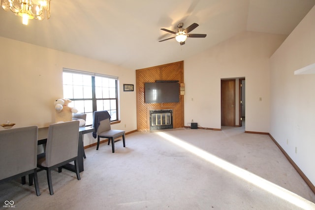 office space with light carpet, vaulted ceiling, baseboards, ceiling fan with notable chandelier, and a large fireplace