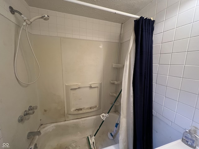 bathroom with shower / bathtub combination with curtain and a textured ceiling