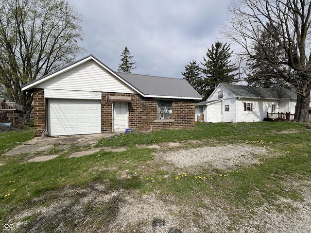 ranch-style house with a garage, brick siding, and metal roof