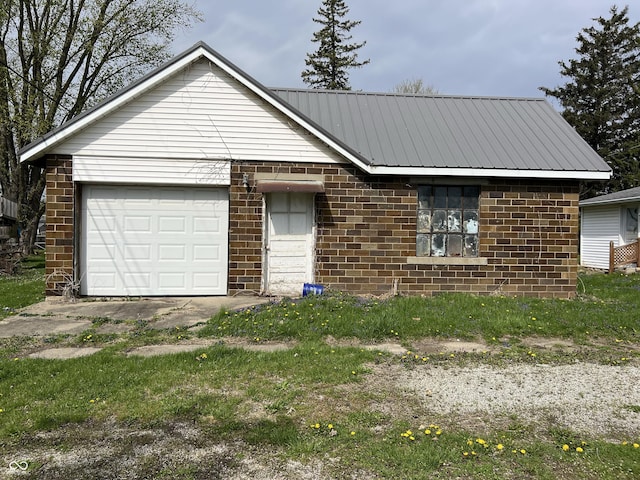 single story home featuring metal roof, an attached garage, and brick siding