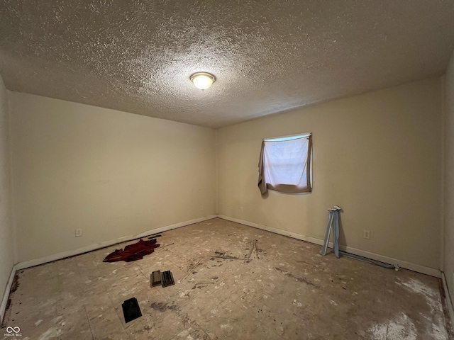 unfurnished room featuring a textured ceiling