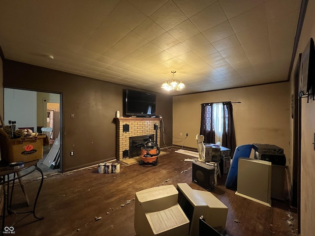 living area with wood finished floors, a notable chandelier, and a brick fireplace