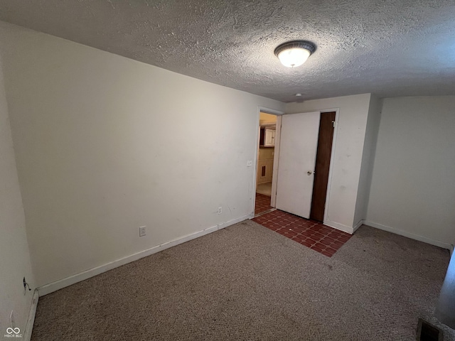 unfurnished room with carpet, visible vents, a textured ceiling, and baseboards