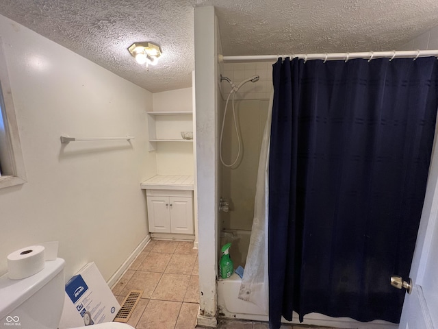 bathroom featuring shower / bath combination with curtain, toilet, a textured ceiling, baseboards, and tile patterned flooring