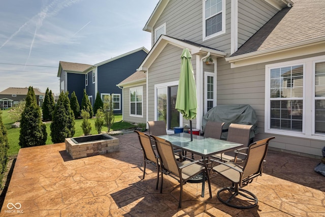 view of patio / terrace with a fire pit, outdoor dining space, and a grill