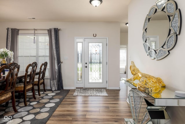 entrance foyer featuring baseboards, wood finished floors, and visible vents