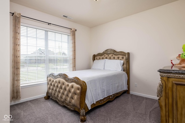 bedroom with baseboards, visible vents, and carpet