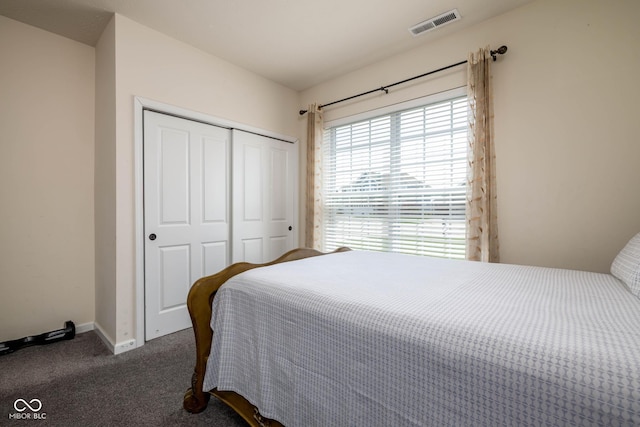 bedroom with baseboards, carpet flooring, visible vents, and a closet
