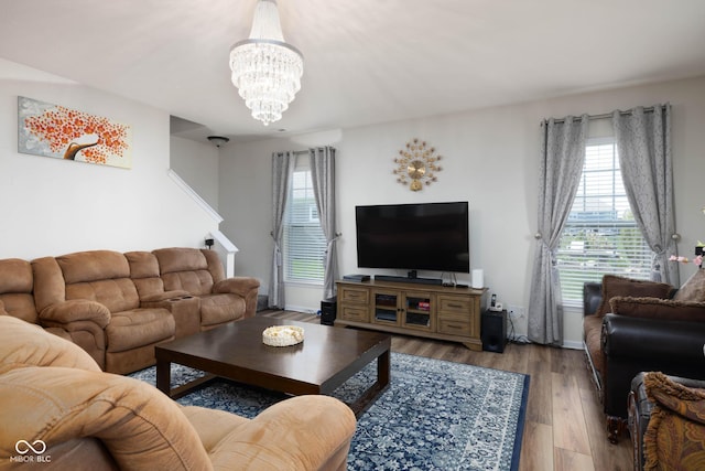 living area with baseboards, wood finished floors, and a chandelier