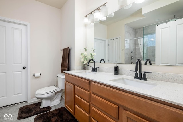 full bath with a sink, a shower stall, double vanity, and toilet