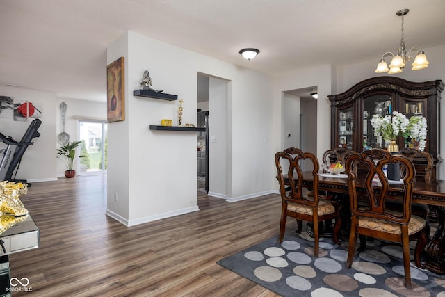 dining area with an inviting chandelier, wood finished floors, and baseboards
