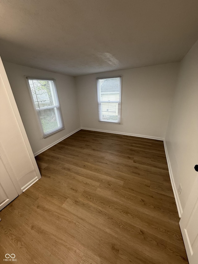 empty room with baseboards and wood finished floors