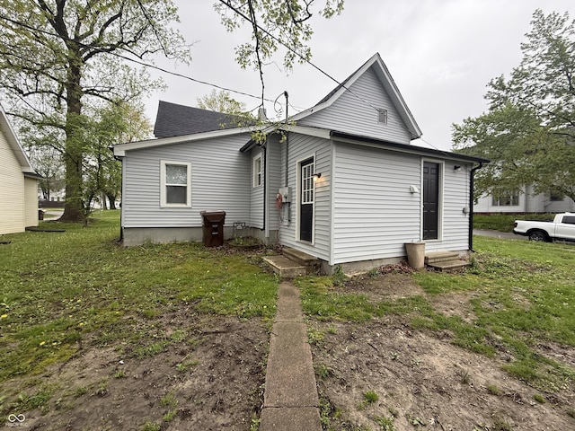 back of property featuring a yard and entry steps