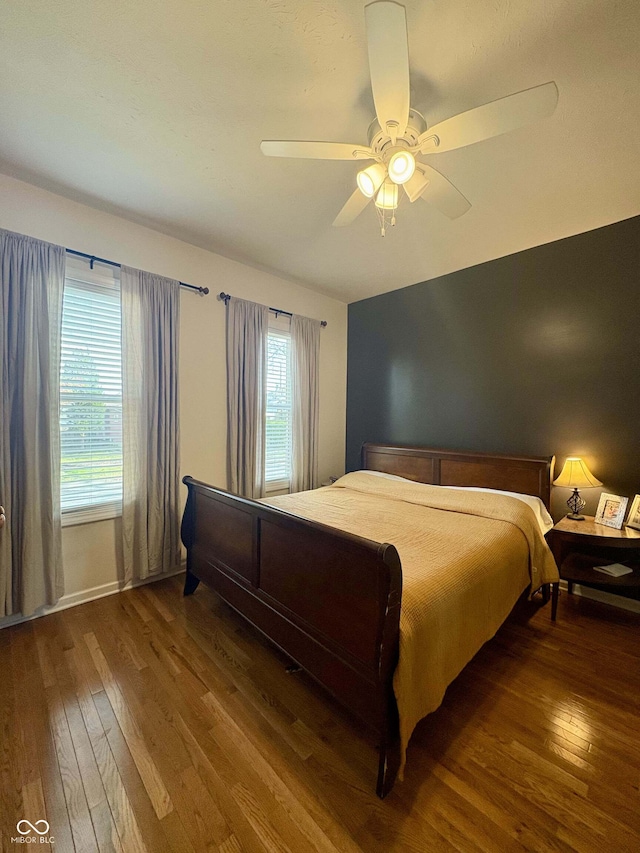 bedroom featuring wood-type flooring and a ceiling fan