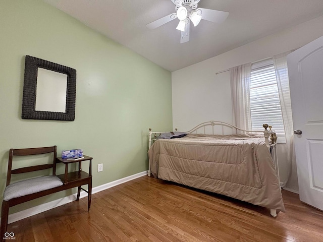 bedroom featuring baseboards, a ceiling fan, vaulted ceiling, and wood finished floors