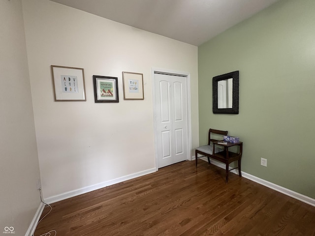 interior space with baseboards, a closet, and dark wood-style flooring