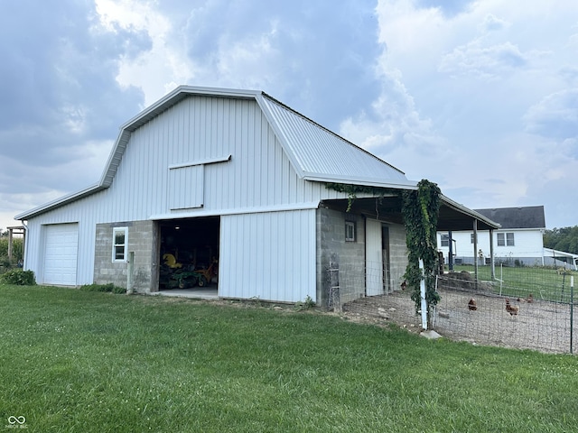view of barn with a lawn and fence