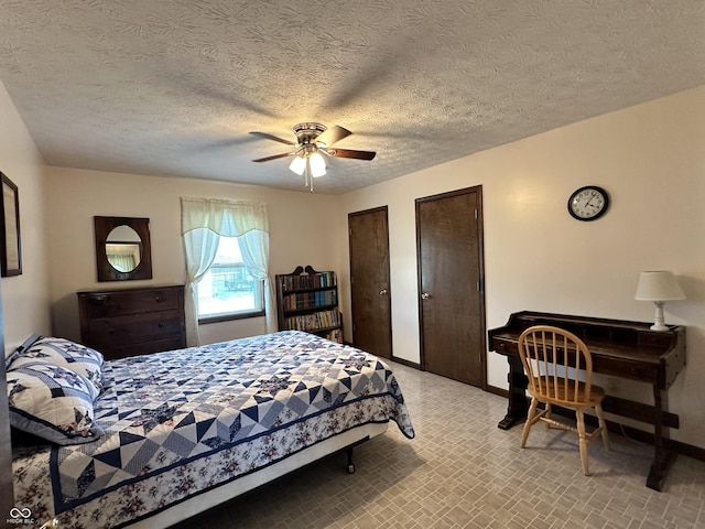 bedroom featuring a textured ceiling, multiple closets, a ceiling fan, and baseboards