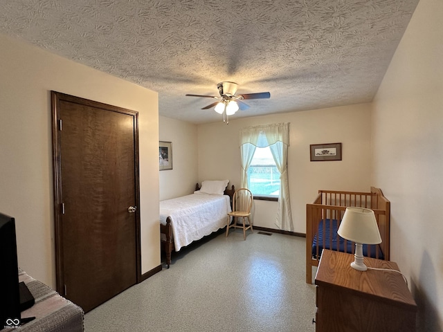bedroom with visible vents, a ceiling fan, baseboards, and a textured ceiling