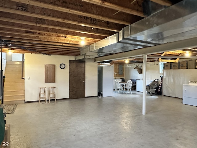 unfinished basement with electric panel and washer / clothes dryer