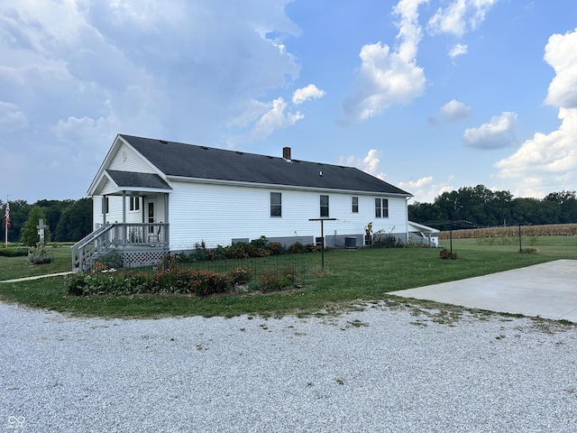 view of property exterior with a chimney, a yard, and central AC