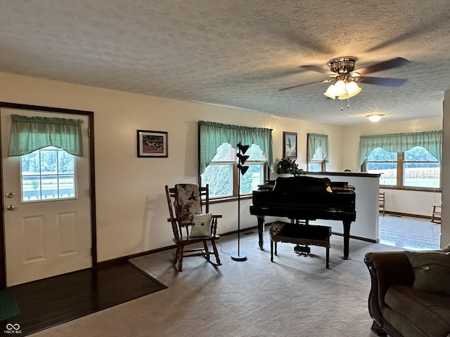 living area with plenty of natural light, carpet floors, baseboards, and ceiling fan